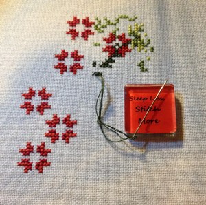 First stitches.  I stitched the poinsettias first to have an easy reference when I started the greenery.